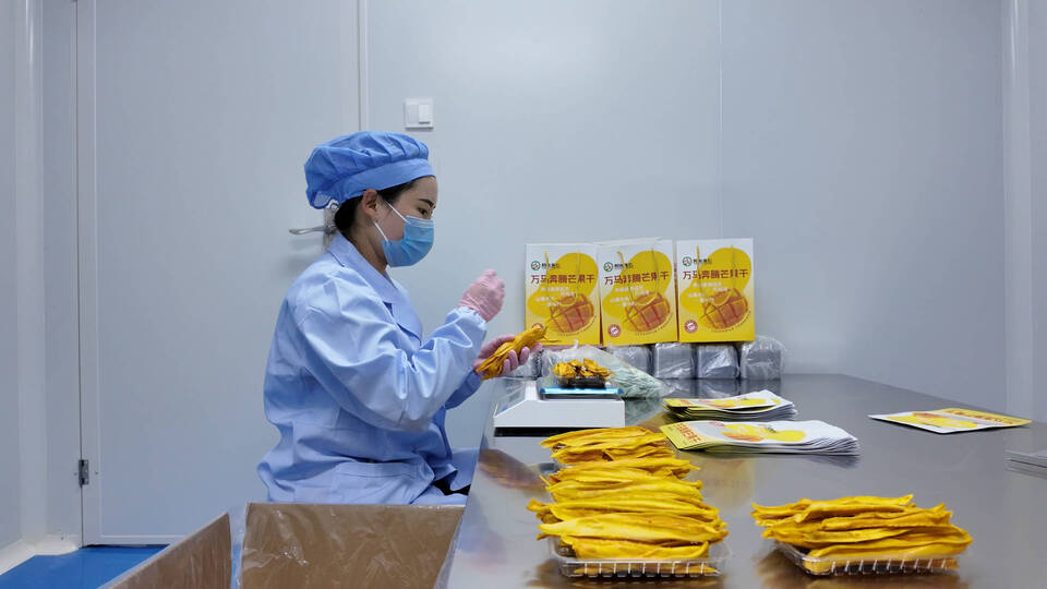 2025.9.23工人正在包装芒果干.jpg